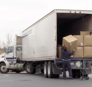 En la imagen se muestra un hombre cargando mercancía a un camión