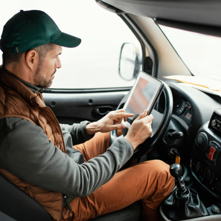 En la imagen se observa un conductor de camión sujetando una tableta