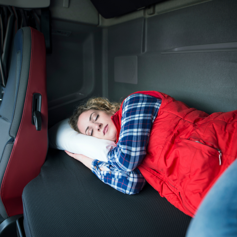 En la imagen se observa una mujer durmiendo en la cabina de un camión