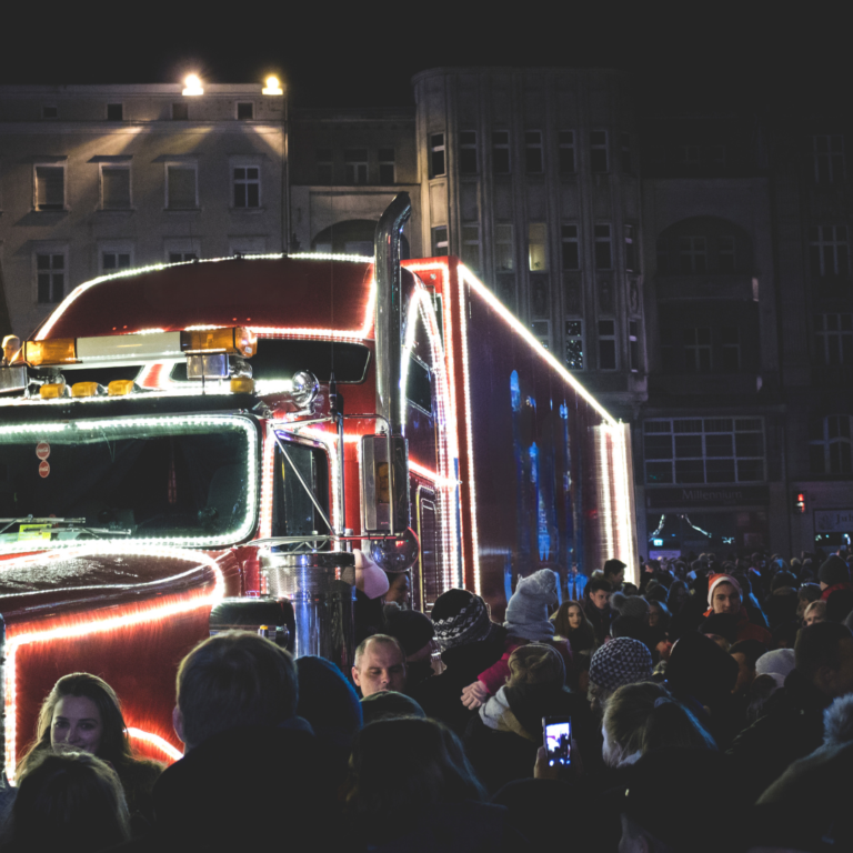 En la imagen se muestra un camión con luces rodeado de personas