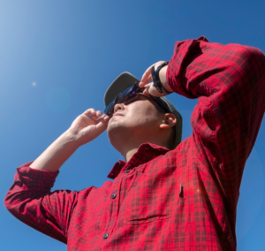 En la imagen se muestra un hombre con lentes para ver un eclipse solar