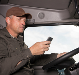 En la imagen se muestra una persona conduciendo con el móvil en mano