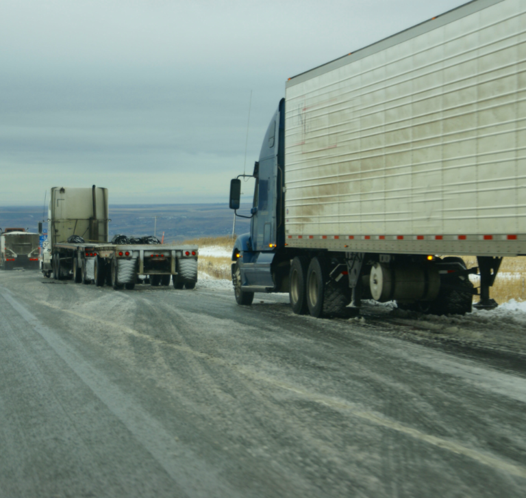 En la imagen se muestran dos camiones conduciendo en la nieve